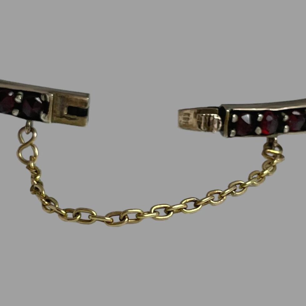 A close up photo of the clasp area shown open with the safety chain almost fully extended.