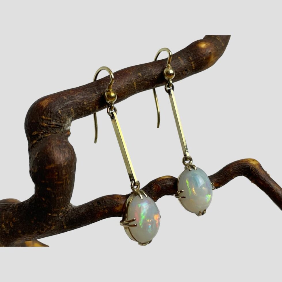 Photo of earrings still displayed hanging from a twig of cherry tree this time with the earring fronts facing towards the right.