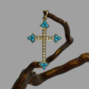 Main photo of antique 18Kt gold cross displayed hanging from a twig from a cherry tree by its bail. This petite antique cross has arrow head tips set with 3 sleeping beauty turquoise stones and seed pearls lining the rest of the cross. A fine gold chain would be ideal for this cross.