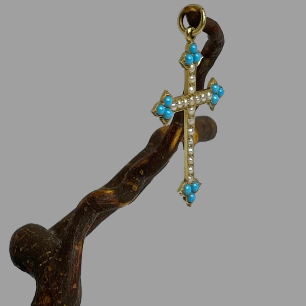 Photo of cross still displayed hanging from a cherry twig this time seen from a side view with the cross front facing the right.