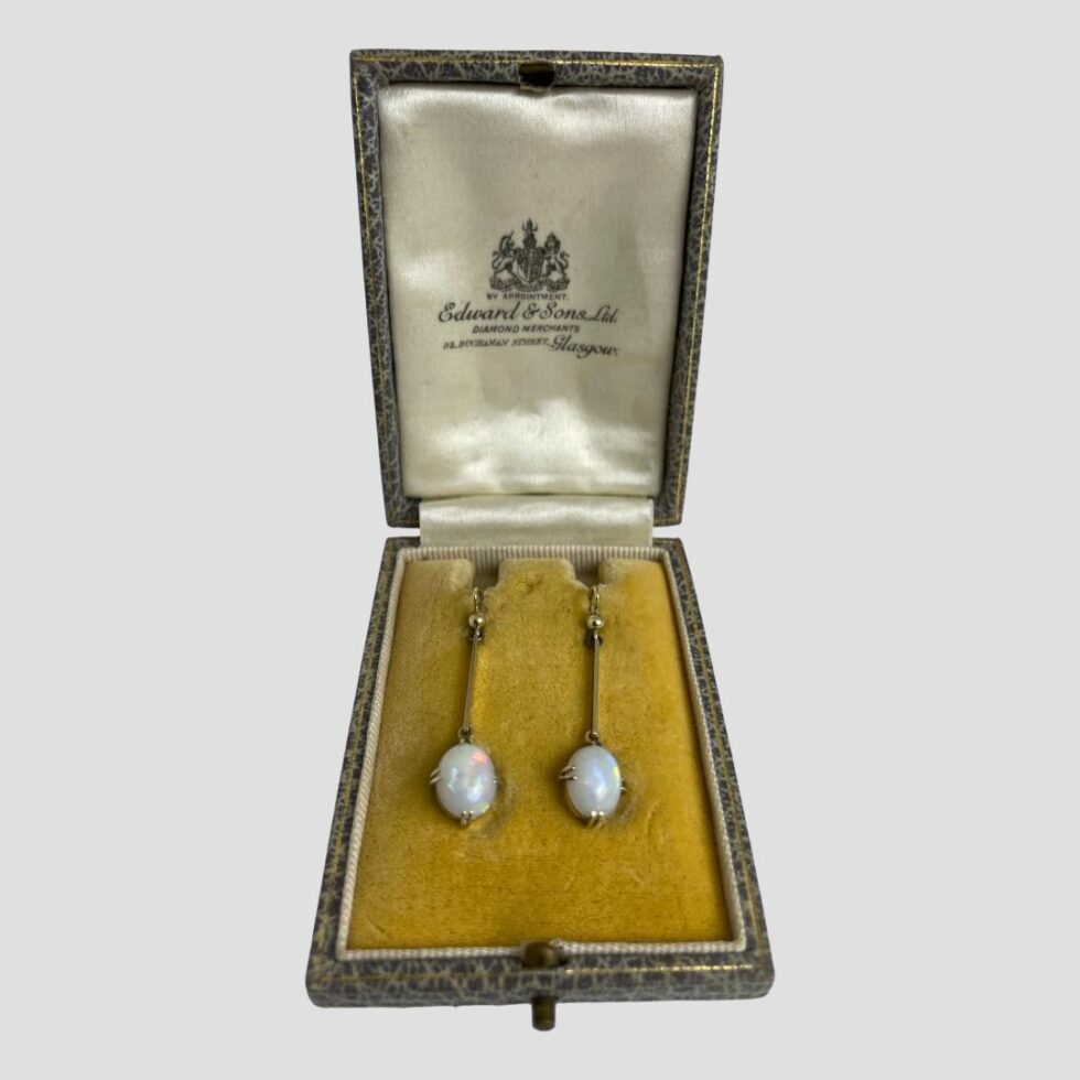 Photo of antique gold opal earrings displayed inside their original antique box .