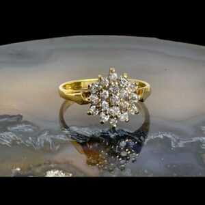 Main photo of .50 carat diamond ring displayed on top of a slice of natural agate with the ring front forward facing. Each of the 19 diamonds are individually pin set giving each sparkling rights! All set on 18 karat yellow gold, this is a true bling ring.