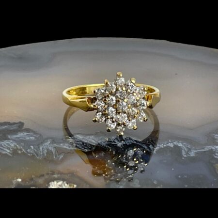 Main photo of .50 carat diamond ring displayed on top of a slice of natural agate with the ring front forward facing. Each of the 19 diamonds are individually pin set giving each sparkling rights! All set on 18 karat yellow gold, this is a true bling ring.