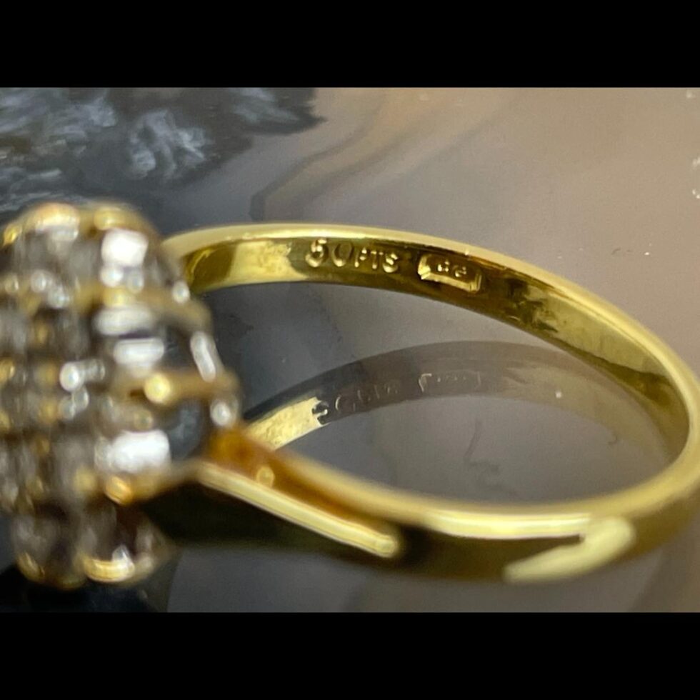 Close up photo of the diamond carat hallmark opposite to the gold hallmark on the inside band.