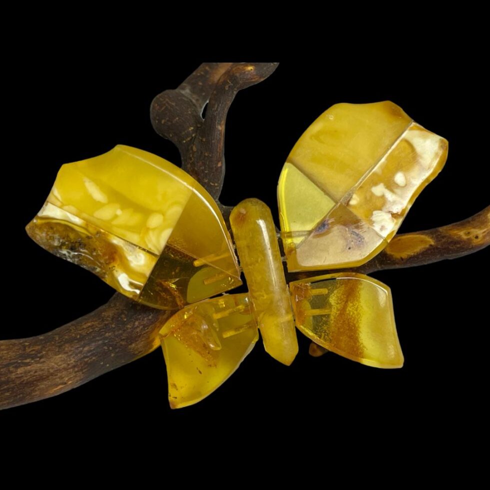 Amber butterfly brooch in close up with the butterfly slightly angled leaning in to the left.