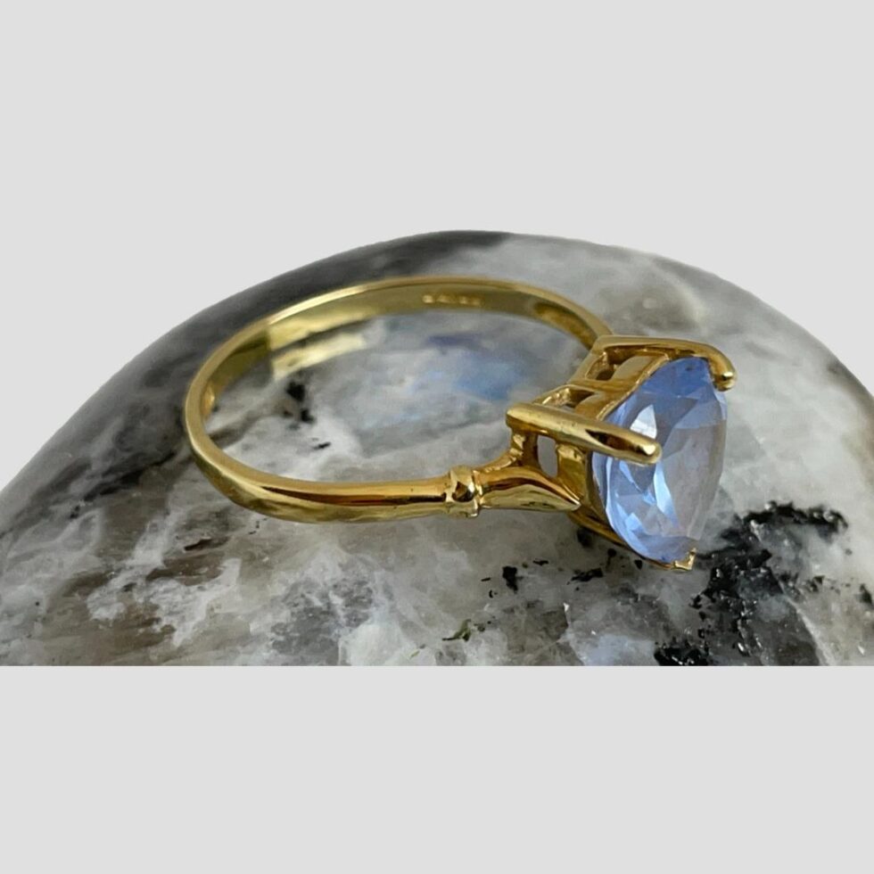 Ring still displayed on moonstone rock this time looking diagonally down from a slight height