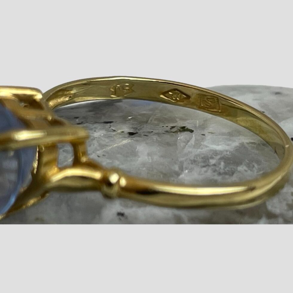 A close up photo of the makers stamps on inside band opposite hallmark.