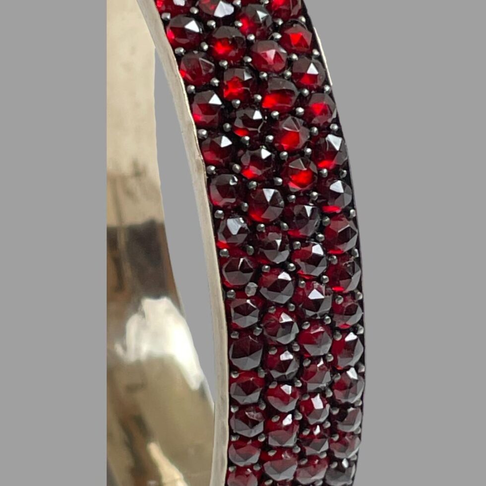 Another close up photo of the garnets showing the 4 rows of faceted deep red stones.
