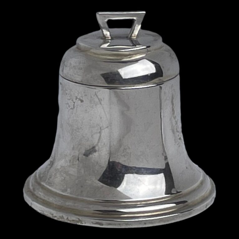 Min photo of antique silver bell inkwell seen with top closed and with the front opening side in the foreground. There is a little arch shaped handle to the top for opening.