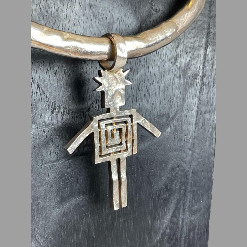 Close up photo of the large pendant with the body of the figure matching the earrings.