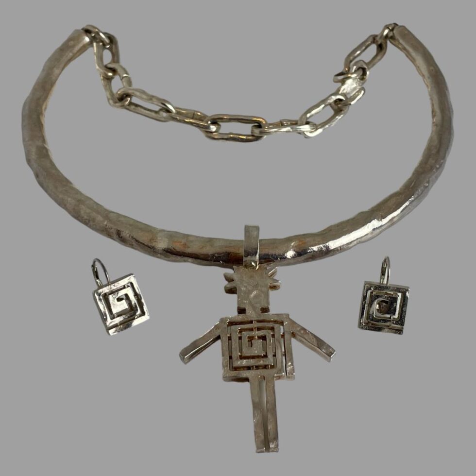 Photo of the set displayed on a flat surface. The pendant is in the centre foreground with the earrings either side. The chain link is visible at the back of the choker/torque front - although looks possibly adjustable, there is very little room for adjustment!