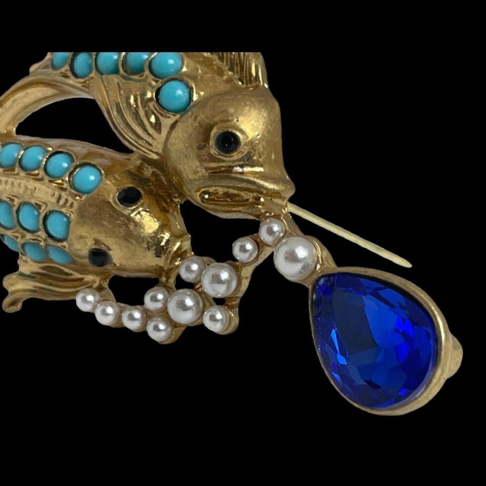 Another close up of the blue glass end of the brooch from opposite angle focusing on the pearly bubbles and fish heads and eyes.
