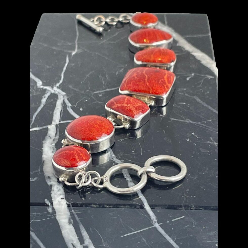 Photo of bracelet seen with the ring clasp end in the foreground and rest of bracelet tapering off towards the back.