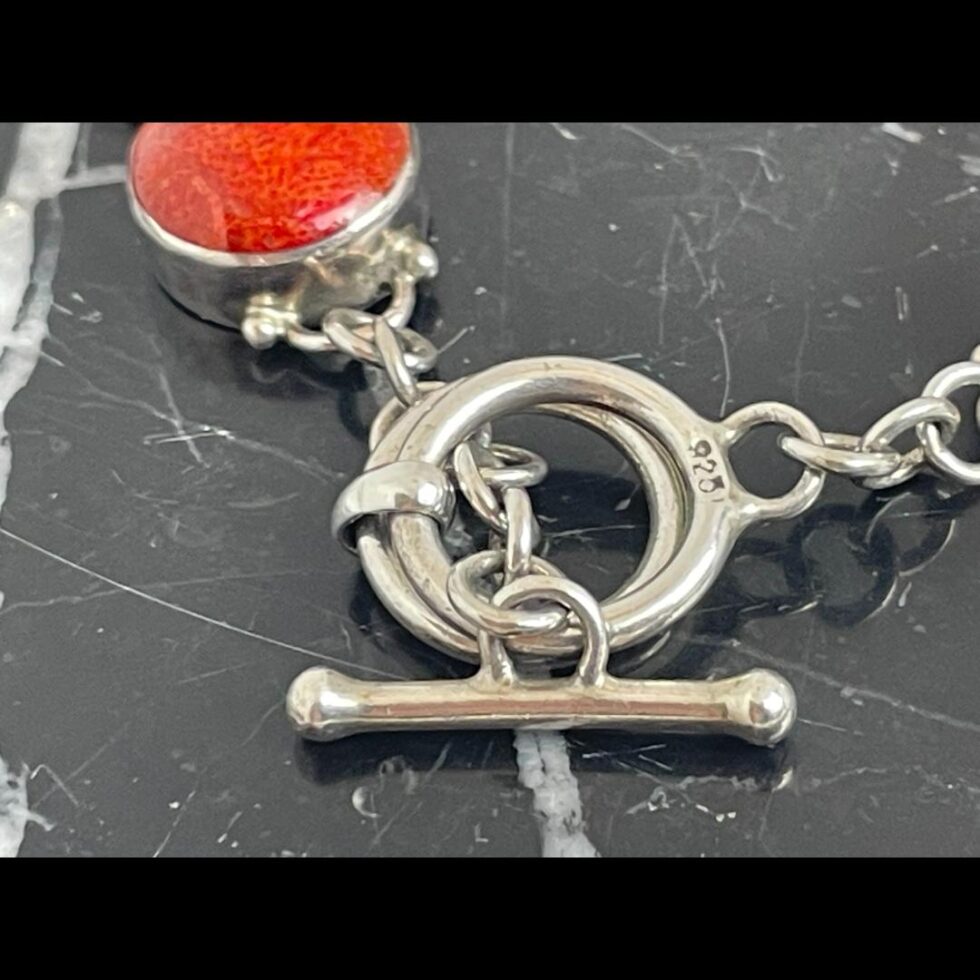 Another close up of the clasp area this time with the toggle going through both rings .