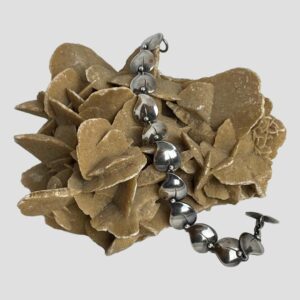 Main photo of N. E. From bracelet displayed across a rock of natural desert sand rose. The whale tail toggle end is in the foreground to the right.