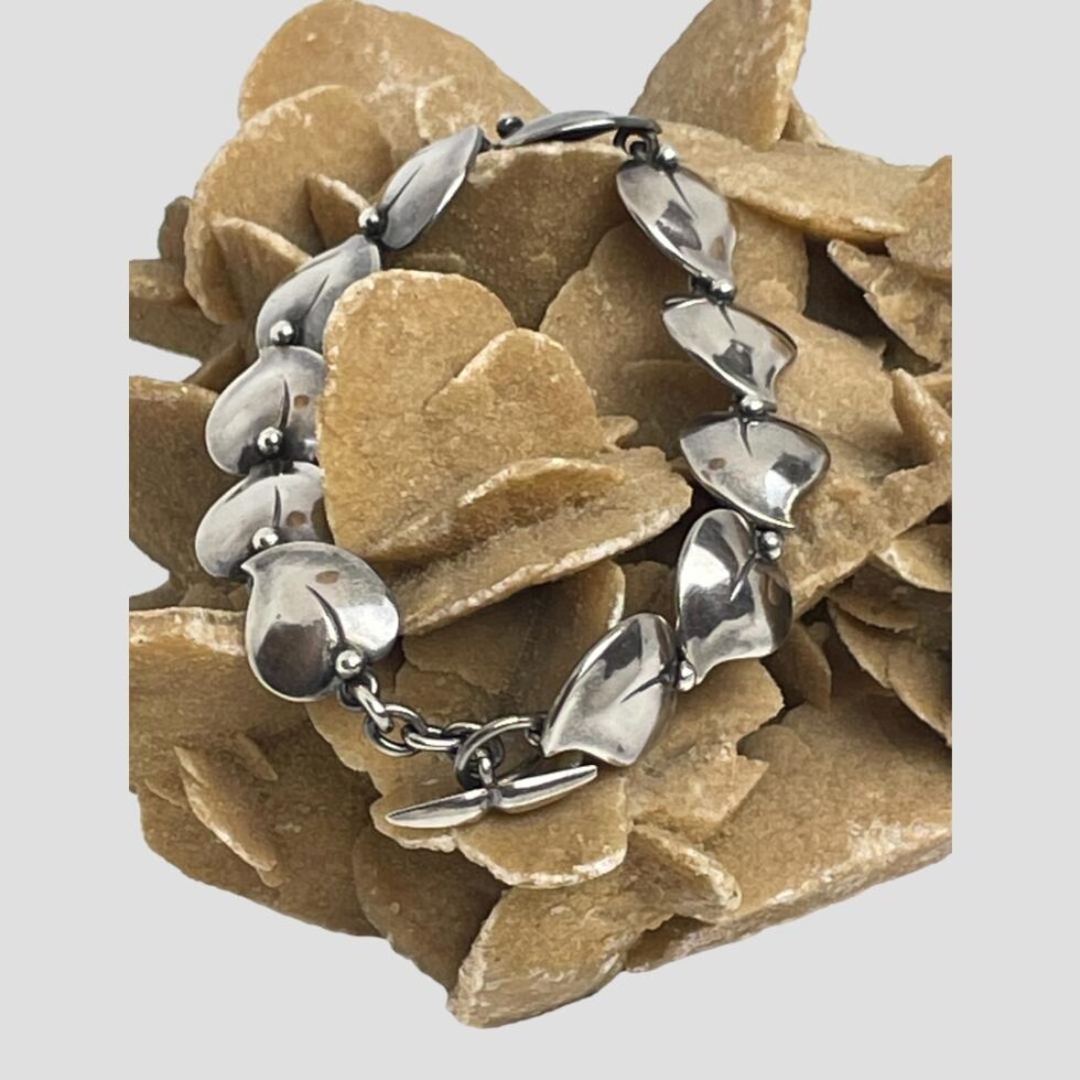 Photo of bracelet displayed on the desert sand rose this time with the clasp closed and the bracelet laid balanced in a ring. The clasp area is dangling below.