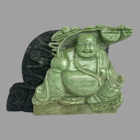 Main photo of lucky Buddha figurine displayed at an eye level with the Buddha forward facing. The front half of the figurine is in a light jade colour and the feng shui coin at the back is a dark green giving a nice contrast. Even with the few chips of the stone, this is a lovely piece.