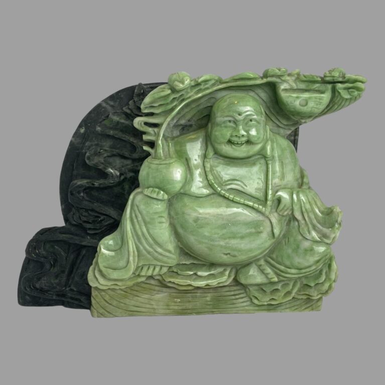 Main photo of lucky Buddha figurine displayed at an eye level with the Buddha forward facing. The front half of the figurine is in a light jade colour and the feng shui coin at the back is a dark green giving a nice contrast. Even with the few chips of the stone, this is a lovely piece.
