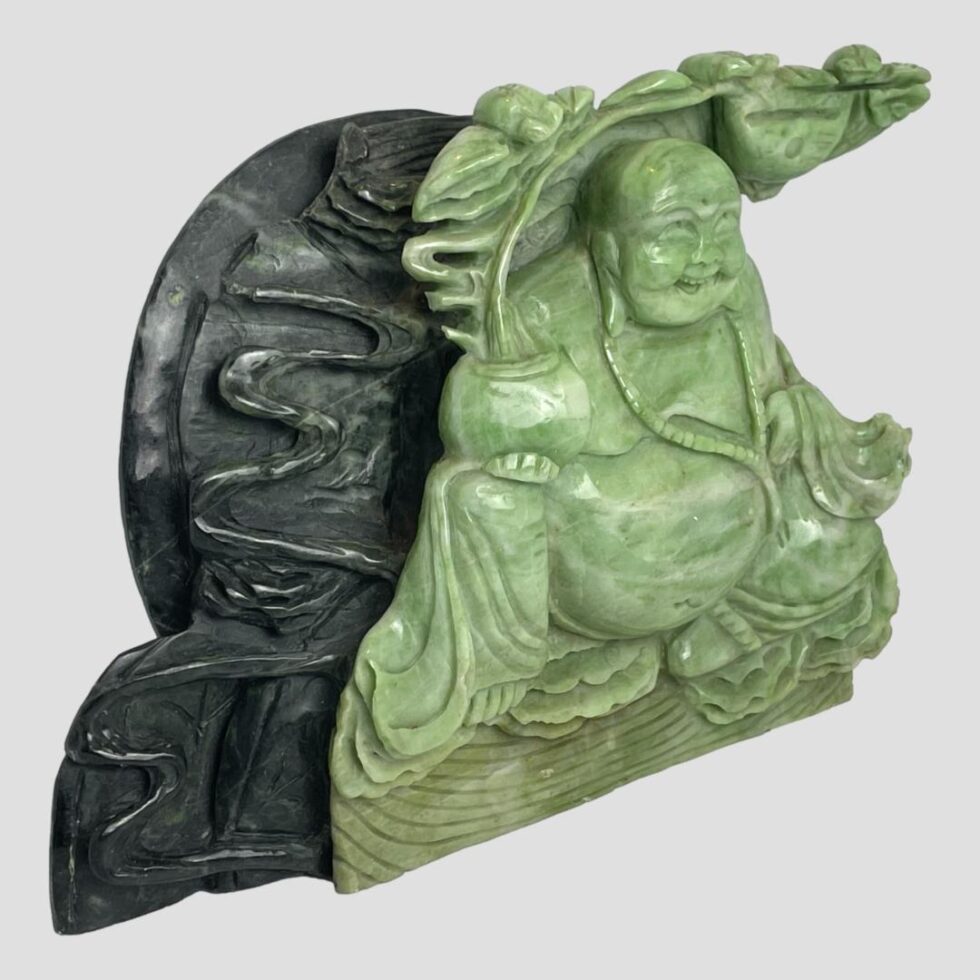 Photo of Buddha figurine seen from a slight side angle with the Buddha facing towards the lower right corner.