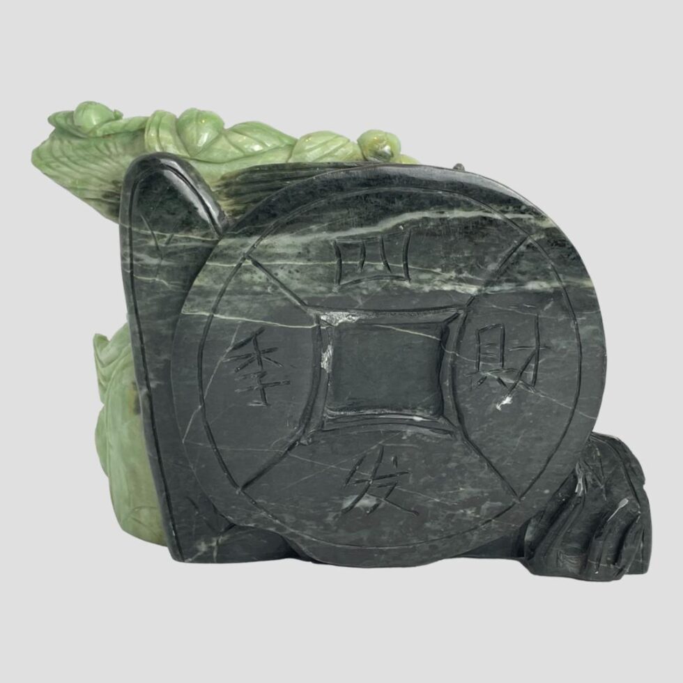 Photo of the back of the lucky Buddha figurine showing the dark green feng shui lucky coin.