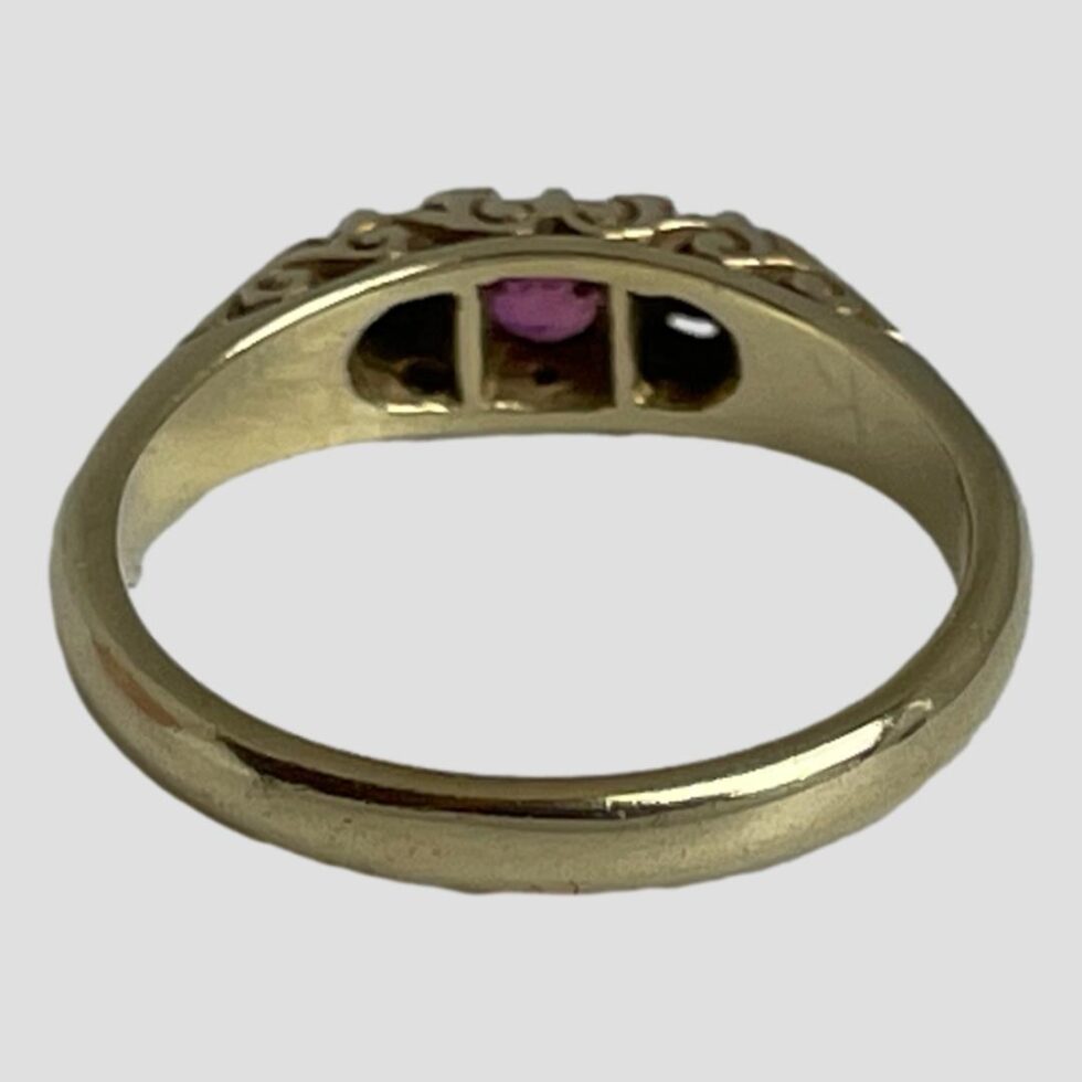 Photo of ring displayed on a flat surface with the ring front facing away from camera. The back of stone setting can just be seen.