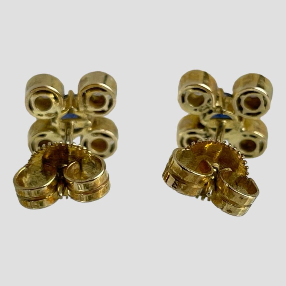 Photo of both earrings shown side by side against a light grey background. Both earrings are facing away from camera and the backs of both are visible. Both earrings have their butterflies in place.