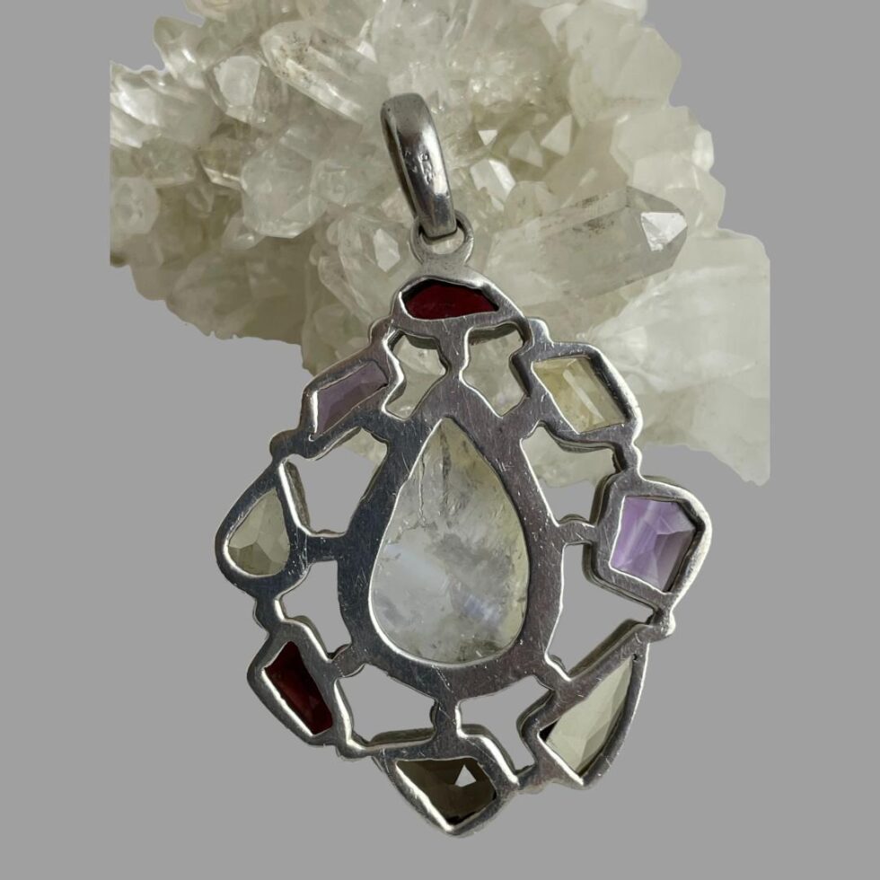 Photo of pendant leaning against the rock of quartz crystal and displayed showing the pendant back.
