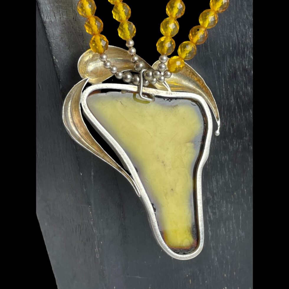 Photo of the back of the egg yolk amber pendant showing the silver frame setting.