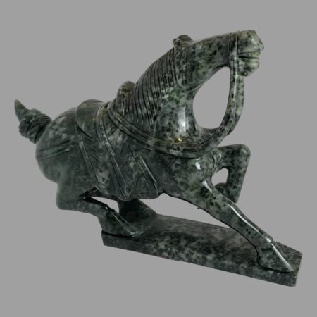 Main photo of serpentine stone warrior horse seen from a side angle with the horse facing to the right. The horse has one front leg raised up, the other straight and its hind legs are both lowered as if ready to pounce any moment. The stone has been well carved with a lot of attention to detail and the mottled stone adds extra character. A perfect gift for someone celebrating the year of the horse!