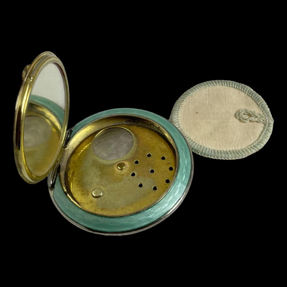 Photo looking down inside the compact showing the swivel mechanism for powder dispensing. The swivel has 2 dispensing options, sprinkle (like a pepper pot) or bulk (an open circle) a little like the old containers of table salt.