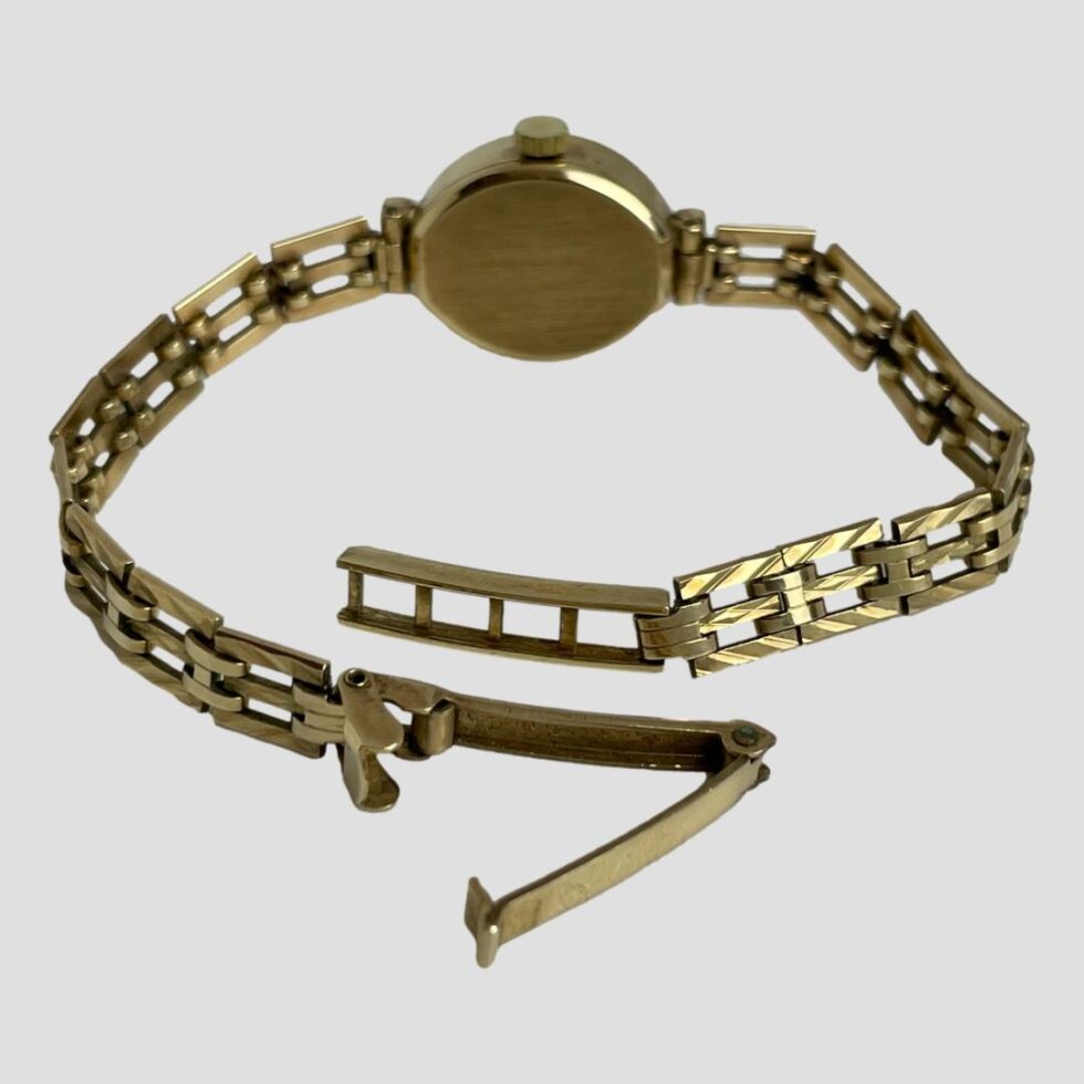 Photo of ladies Rotary watch displayed on a flat surface with the watch face facing away from the camera and clasp is in foreground. The clasp is shown open and undone.