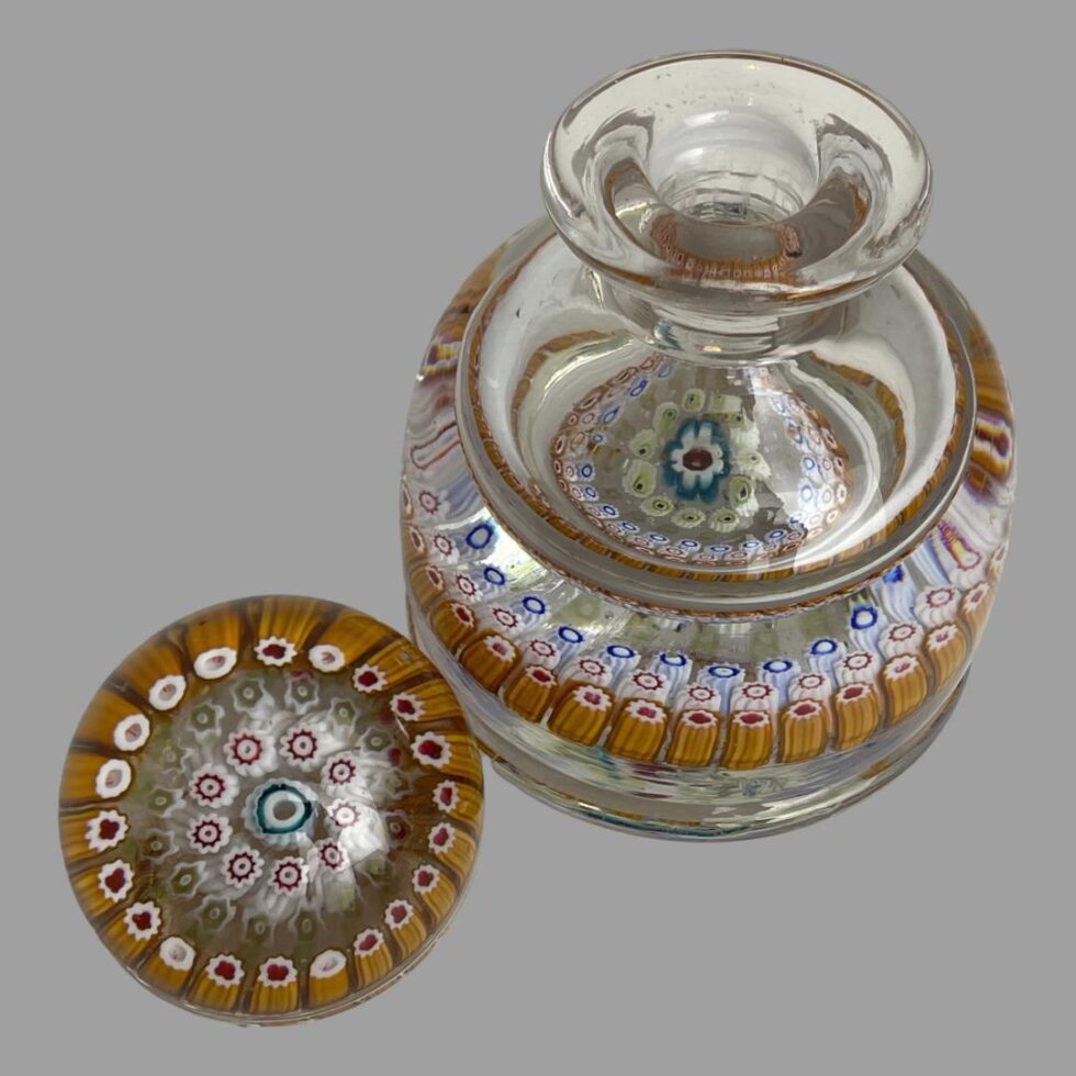 Photo looking diagonally down at the inkwell from above. The lid has been removed and placed at bottom left corner with the millefiori side facing up. Again, from this angle, it is hard to spot any damage to this piece.