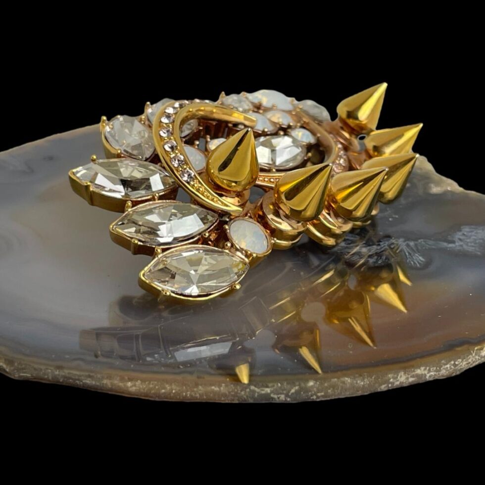 Photo of Mawi London designer brooch still displayed on a slice of natural agate this time with the angle changed to a side view. At this angle, you can see the height of the spikes.
