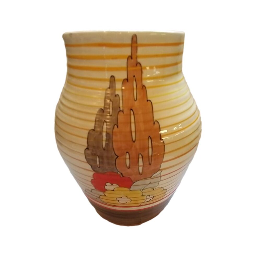 another decorated area with a tall terracotta colour tree with shorter brown one on its left. 2 yellow and one orange flower in the foreground.