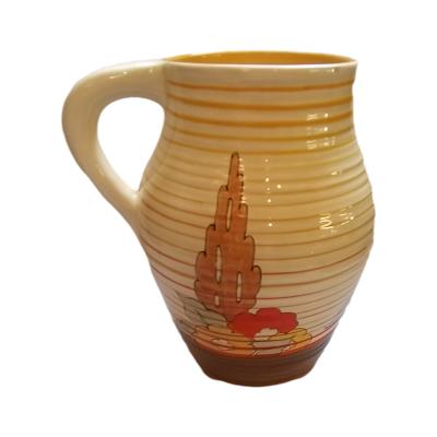 Photo of the opposite side of the jug with the handle on the left. This side has one tree with a few flowers.