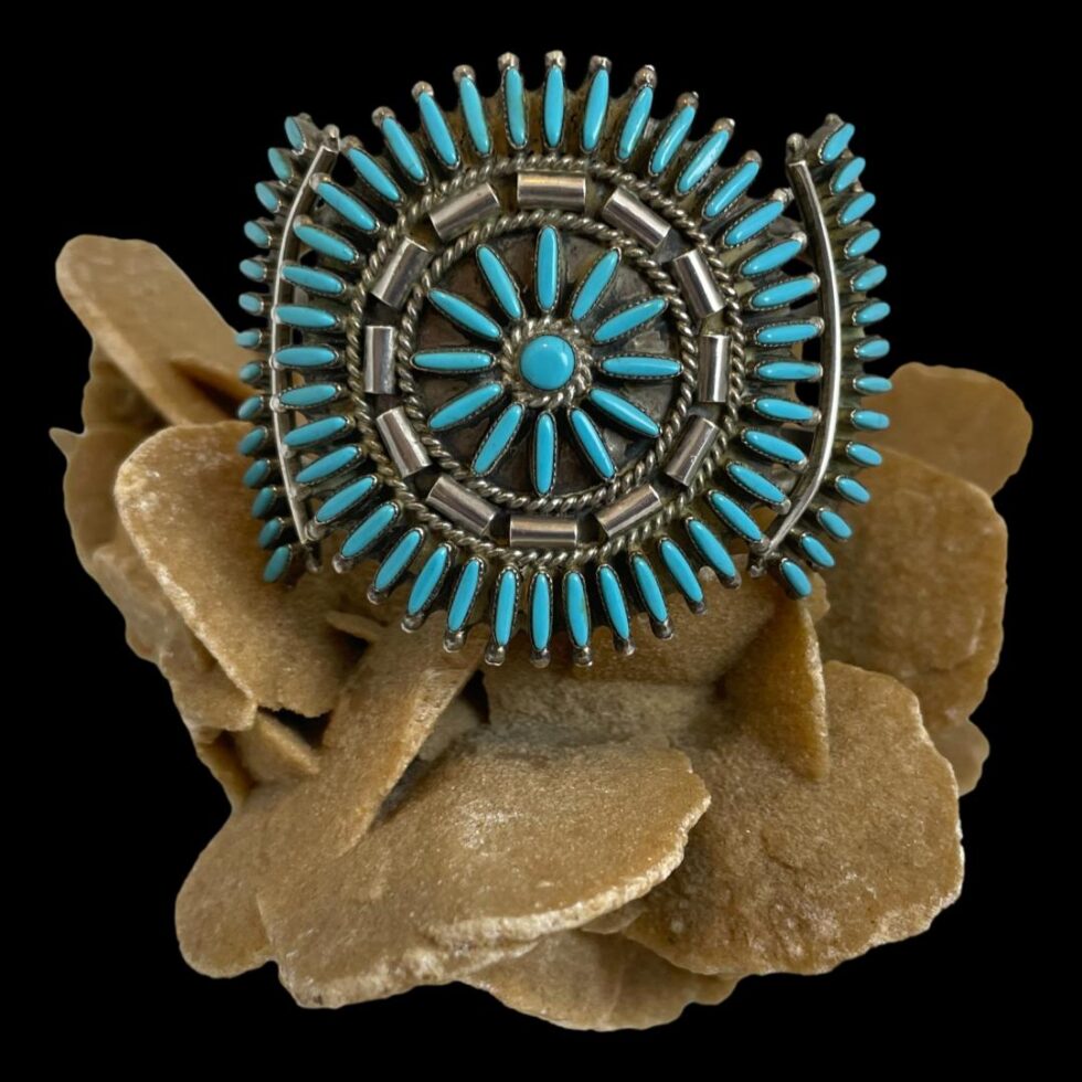 Photo of cuff bracelet only displayed on top of the rock of natural desert sand rose and shown forward facing.