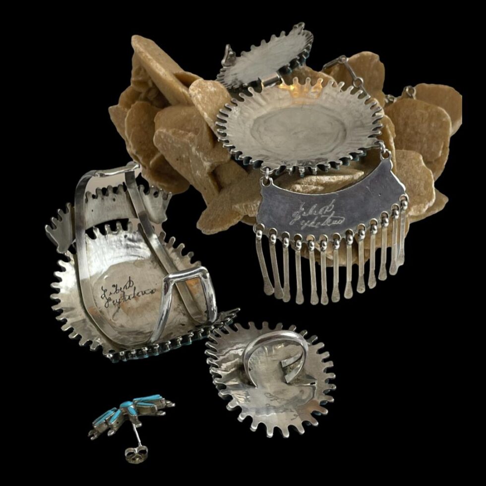 Photo displaying the backs of all pieces except earrings showing the artists signature to each piece.