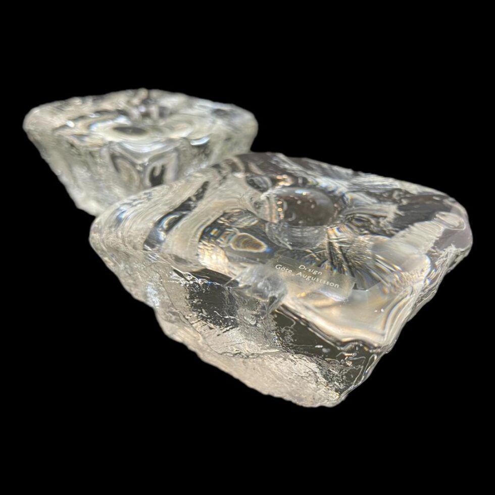 Main photo of ice cube candle sticks displayed side by side with one in the bottom right foreground and other in top left background. The ice like quality is incredible - they even look like they are melting with water droplets visible.