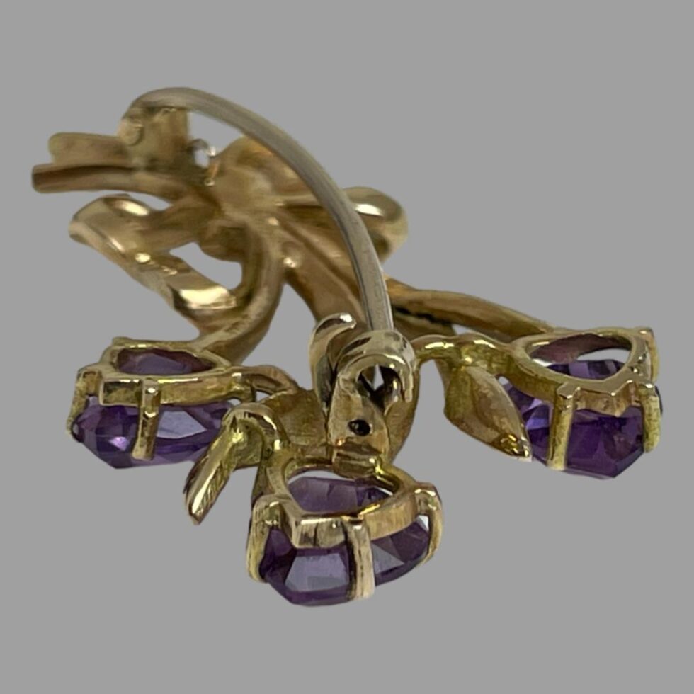 Photo of brooch seen from the back with the tulip flower ends in the foreground. This photo is to show the clasp area and the hook lock clasp.