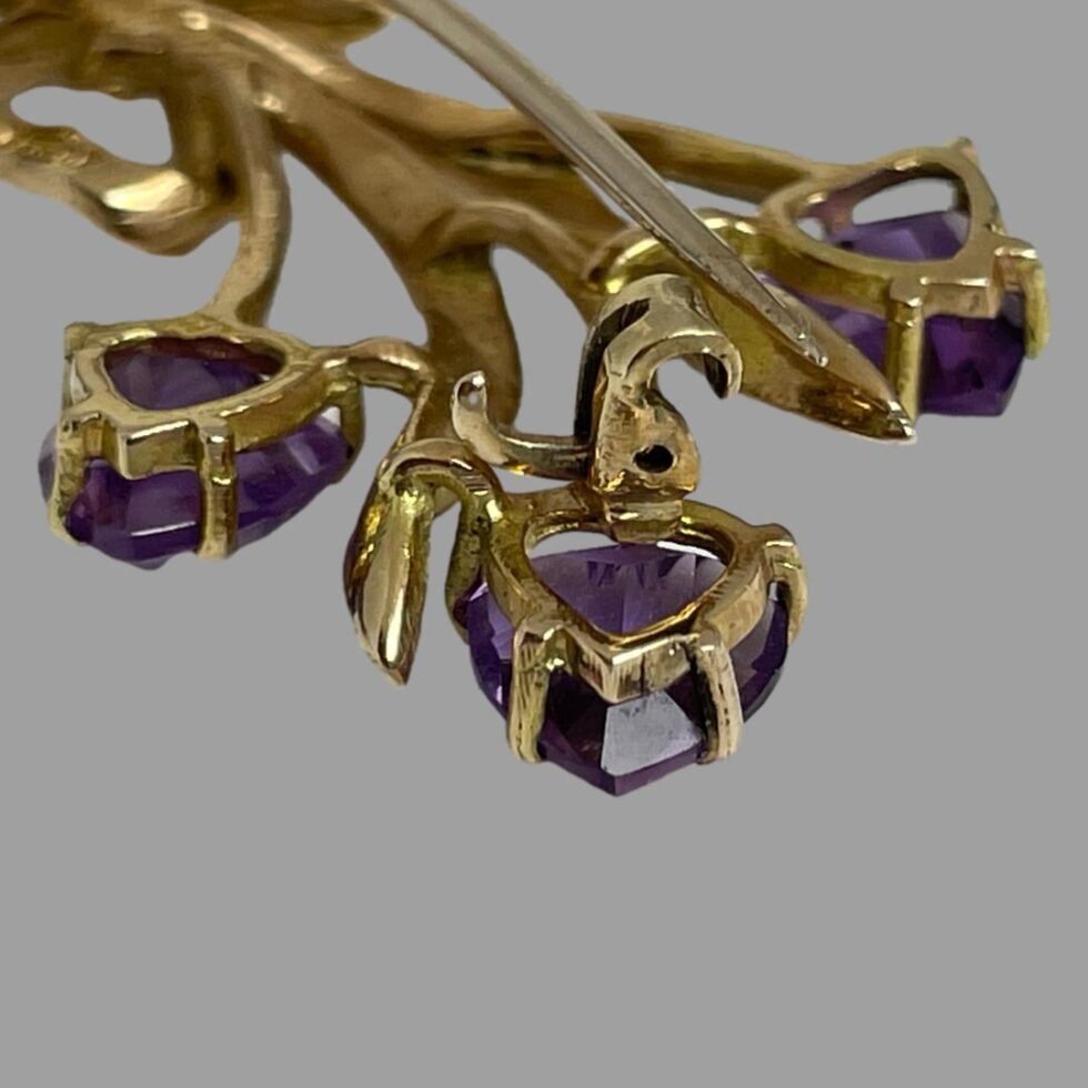 Close up photo of the clasp area of the brooch showing the pin undone and to the right of the clasp. The hook lock clasp design is well visible here.