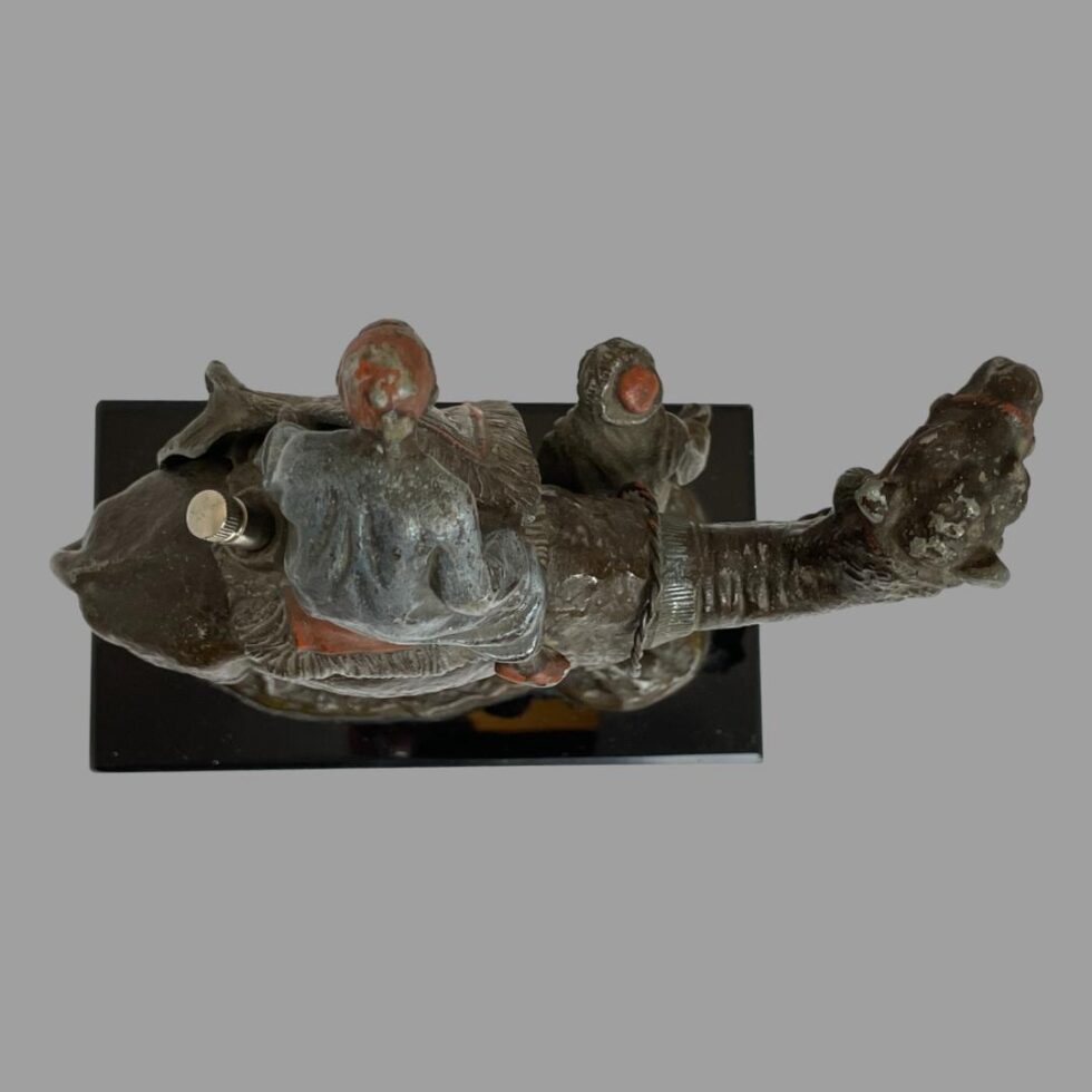 Photo looking straight down at the rug merchants figurine from above. The top of the merchants and camels head is visible.