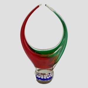 Main photo of retro Murano glass basket seen from an eye level . In this photo, the green handle is on the right and red on the left with some of the red glass merging into the green