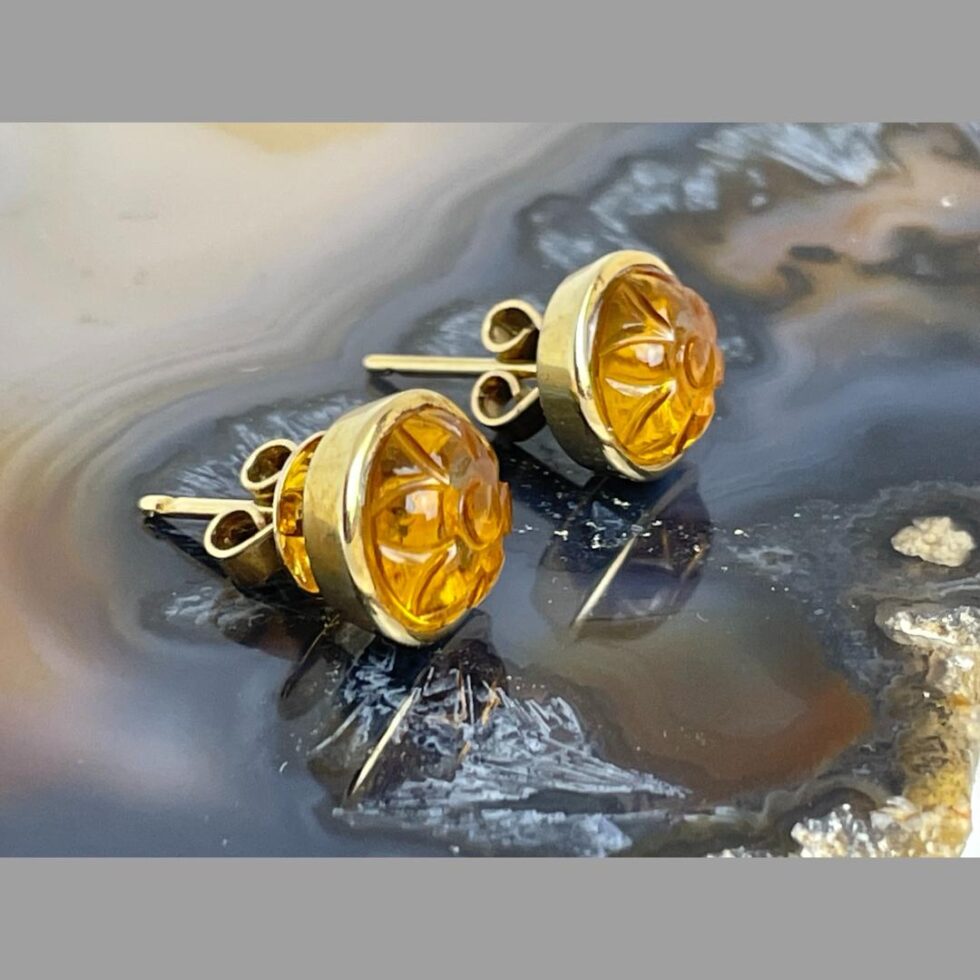 Photo of the carved citrine gold earrings this time both facing right. The outer frame setting of the stones, posts and backs of the butterflies are visible here.