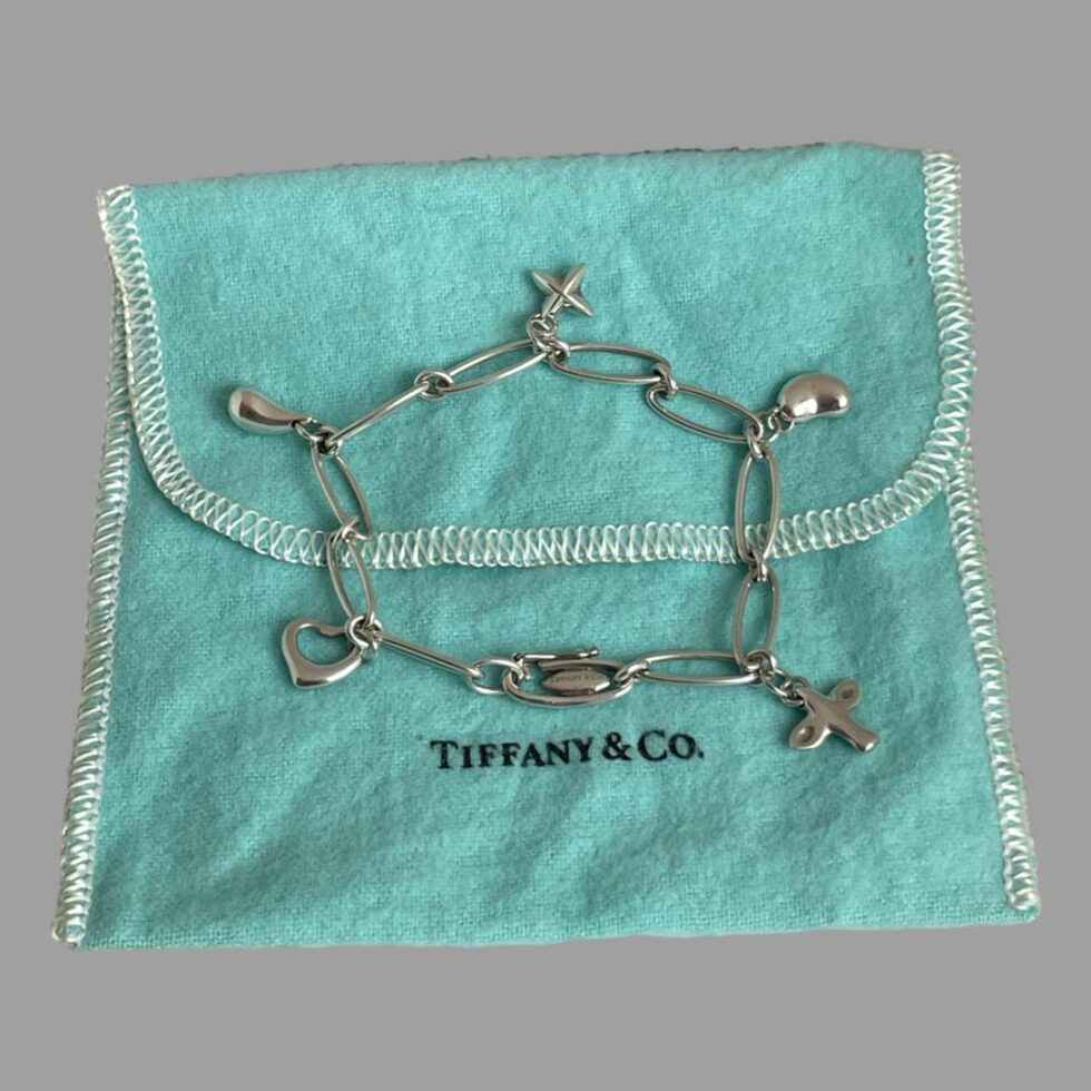 Elsa Peretti Tiffany bracelet is now displayed on top of the Tiffany pouch with each charm extended out to show them clearly.