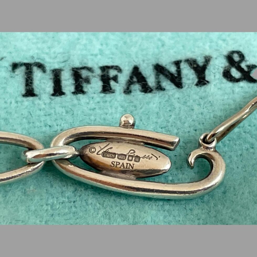 Photo of reverse side of clasp plaque this side has designers signature with full hallmark stamped over the top and SPAIN below that.