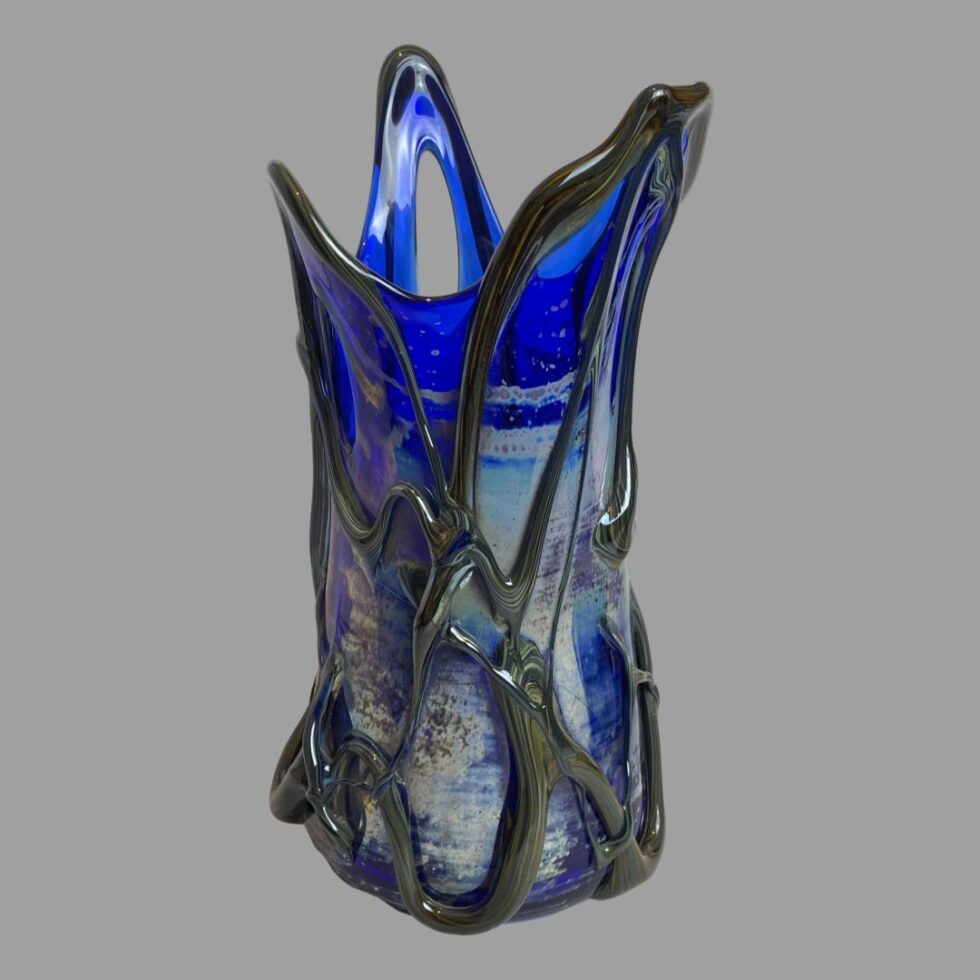 Photo of the 3 pointed tipped vase only seen from an eye level. The vase is shown with 2 of the tips in the foreground - the shortest on the left and tallest and widest to the right. In the background you can see the 3rd pointed tip showing the opening through the glass. All of the 3 pointed tips have a gap in the glass.