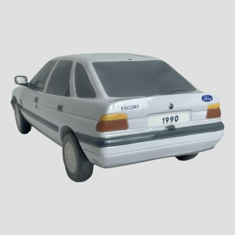 Photo of the back end of the Ford Escort with brake lights in red below the orange indicators. Another blue and white oval FORD badge is on the back right and ESCORT printed opposite on the left.