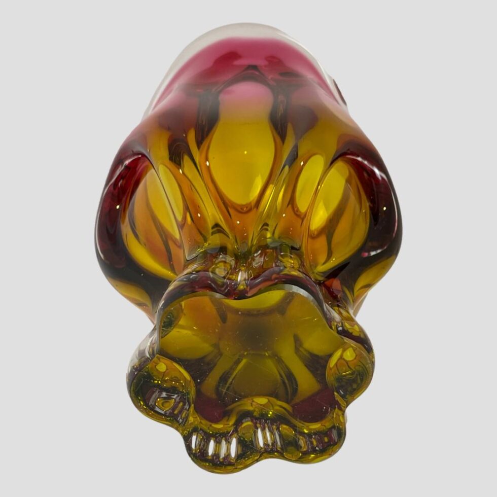 Photo of Josef Hospodka vase displayed laid flat with the bottom of the vase in the foreground. From this angle the base has now taken on the amber glass colour.