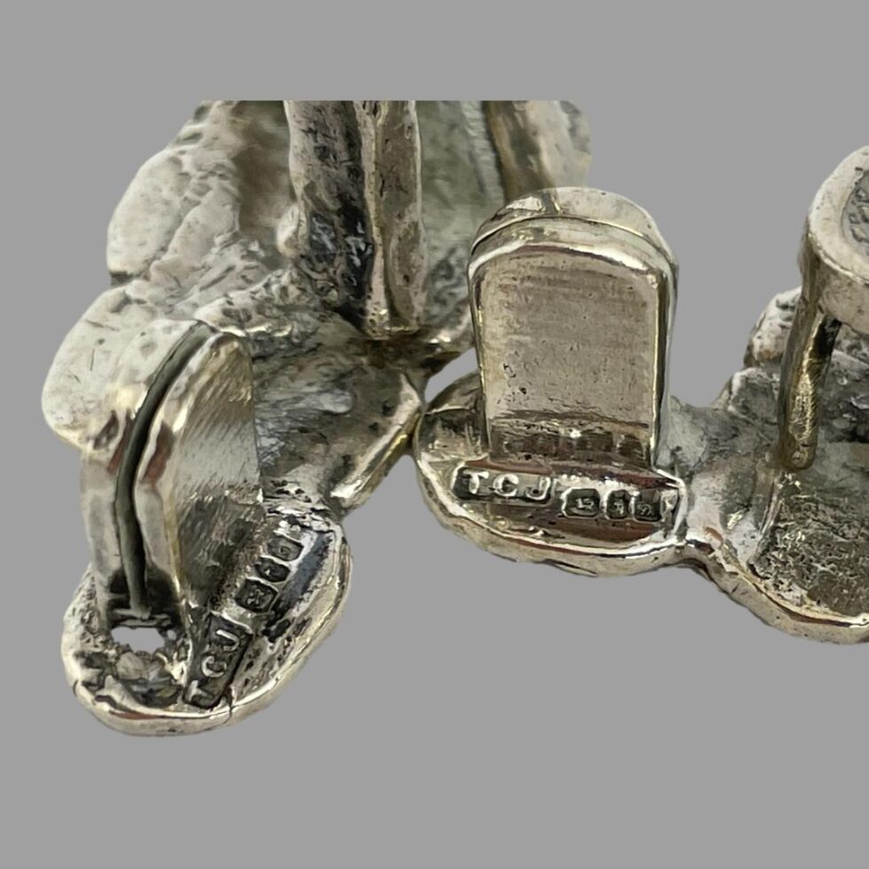 A close up photo of the hallmark on the back of 2 of the milestones. The left hand one is displayed sideways to show the slot for the name / menu card