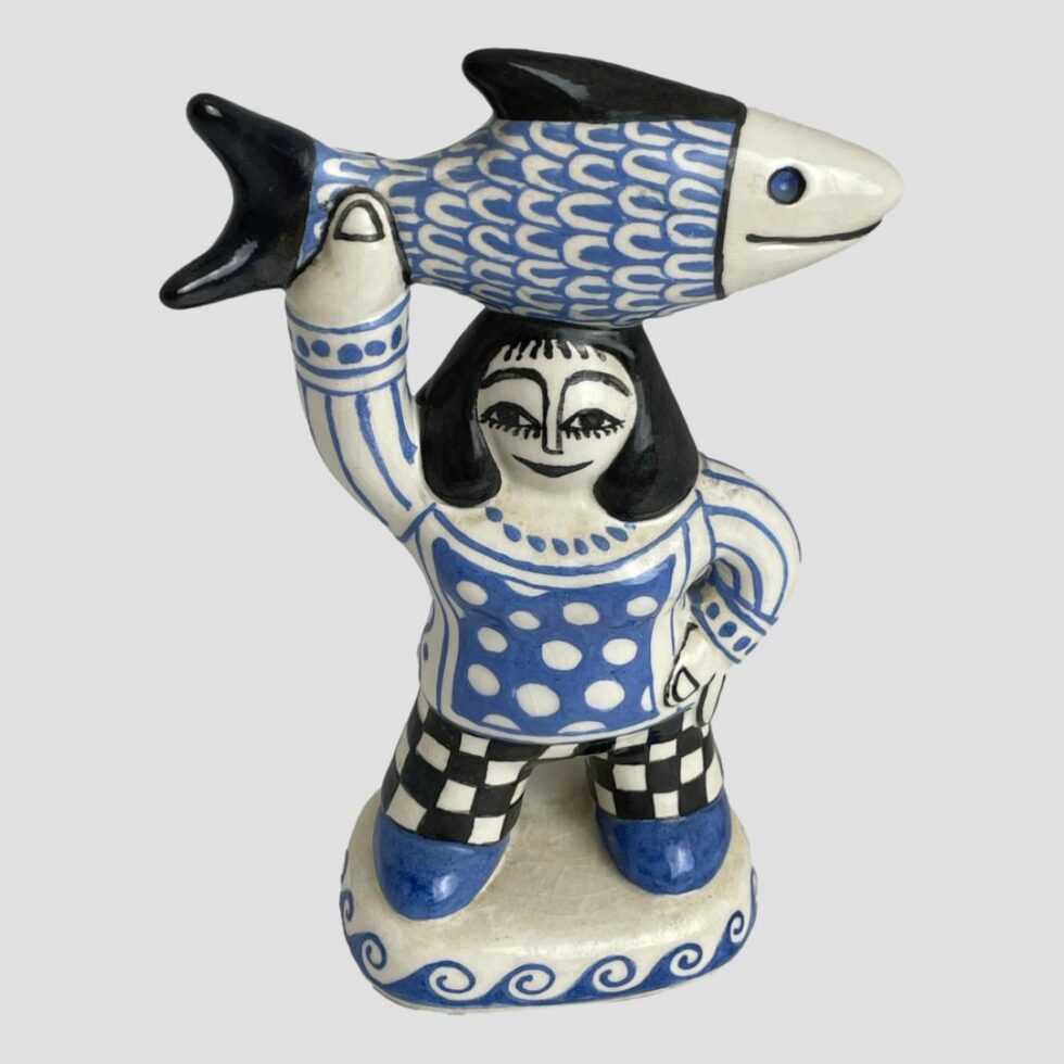 Photo of fisherwoman this time from a slightly raised angle looking diagonally down. Like her hubby, her eyes appear to be following the direction of your gaze.